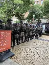 Riot cops line up next to a sign at University of Texas at Austin.
