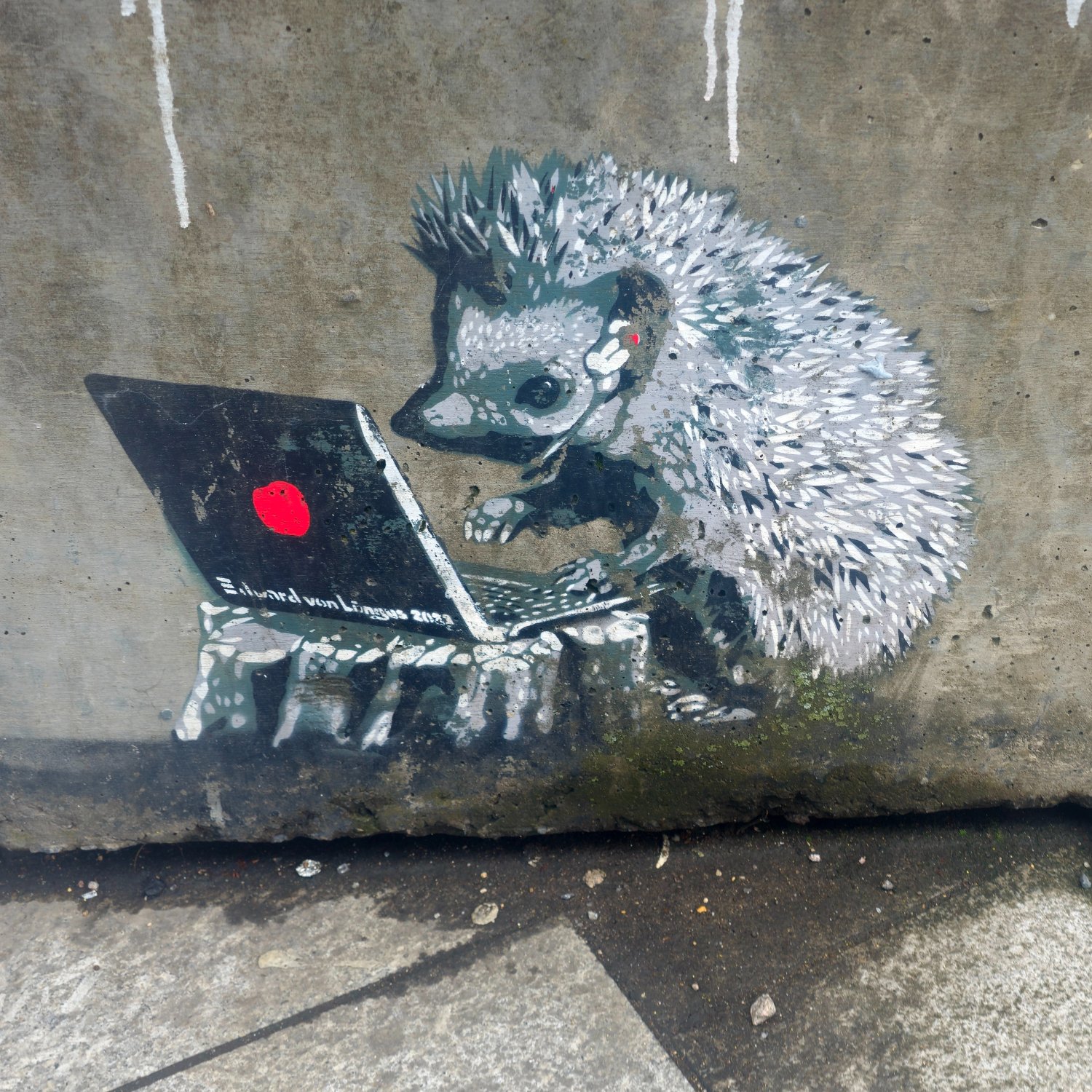 Stencil art of a hedgehog using a laptop on a tree stump and wearing an ear piece with a little microphone