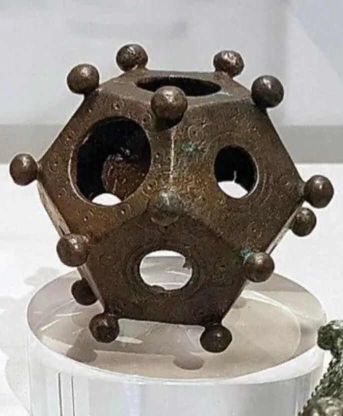 closeup of dodecahedron with three holes appearing like shocked eyes and mouth